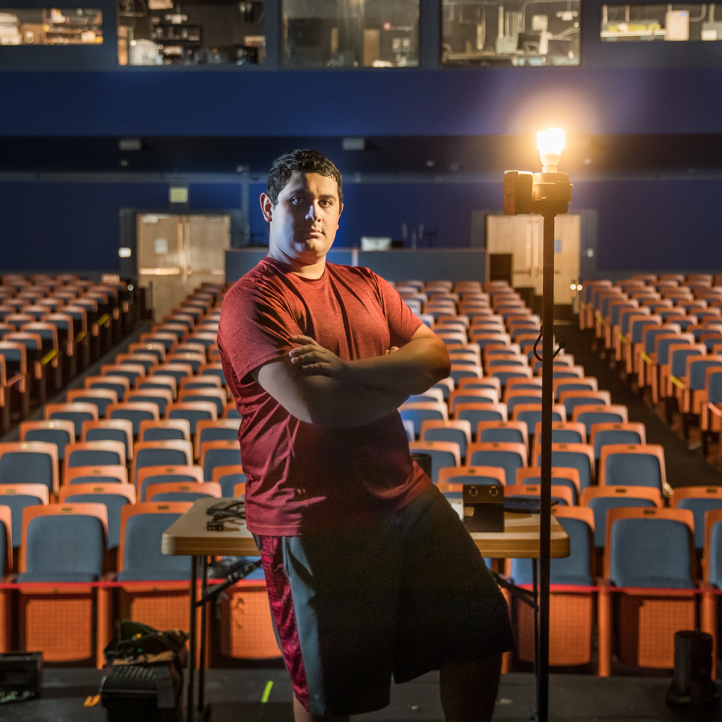 戏剧专业的学生Arteaga站在空荡荡的剧院前的舞台上